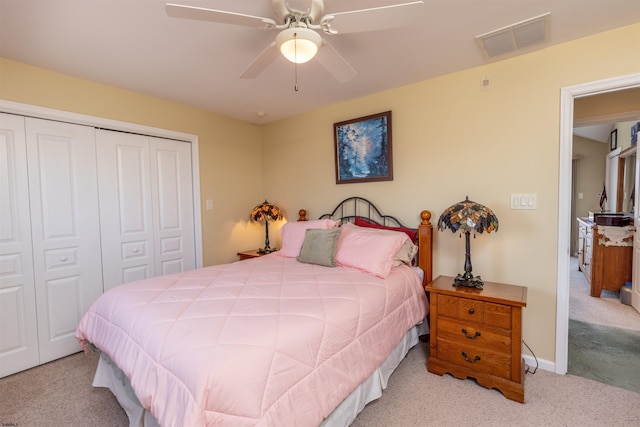 carpeted bedroom featuring baseboards, visible vents, a closet, and ceiling fan