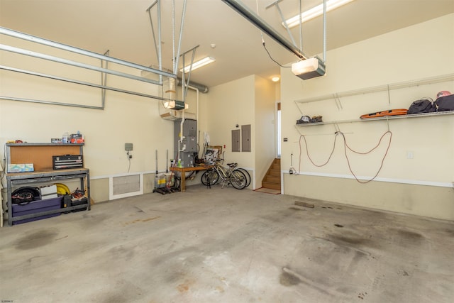 garage featuring electric panel, a workshop area, and a garage door opener