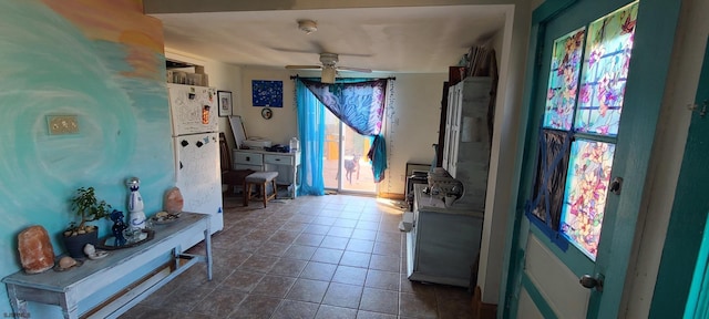 foyer entrance with dark tile patterned flooring, a healthy amount of sunlight, and ceiling fan