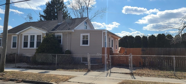 view of side of home featuring a gate and a fenced front yard