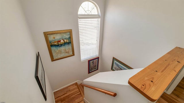 stairway with baseboards and wood finished floors