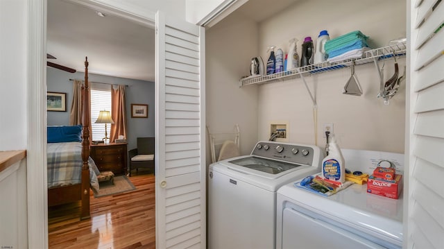 washroom featuring laundry area, washer and dryer, and wood finished floors