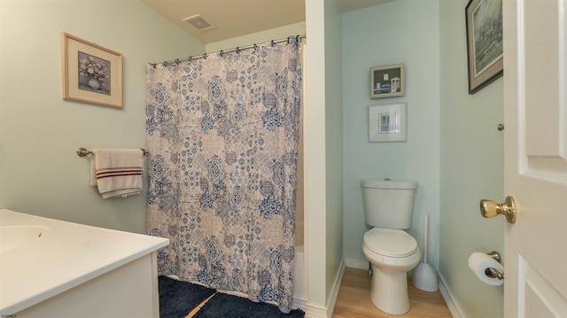 full bathroom with vanity, wood finished floors, visible vents, baseboards, and toilet