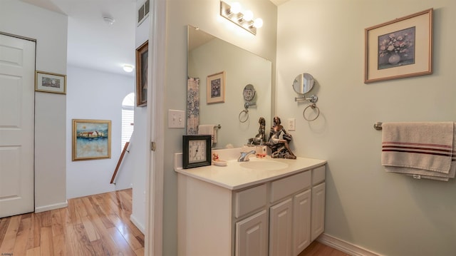 bathroom with visible vents, vanity, and wood finished floors