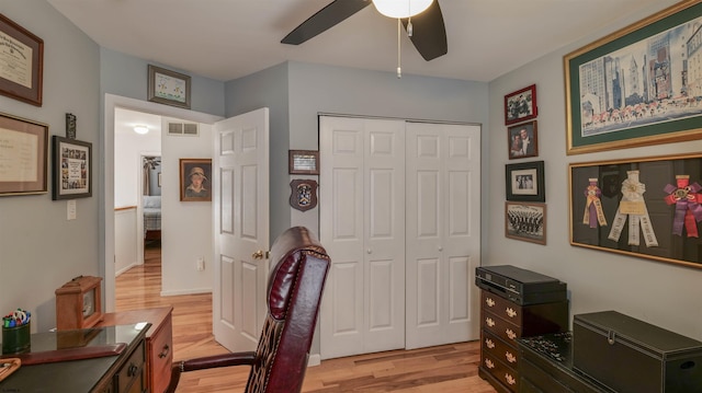 office area featuring light wood finished floors, visible vents, and a ceiling fan