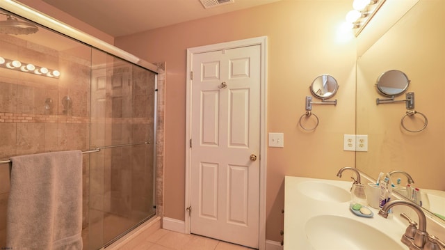 full bath with tile patterned flooring, a stall shower, and a sink