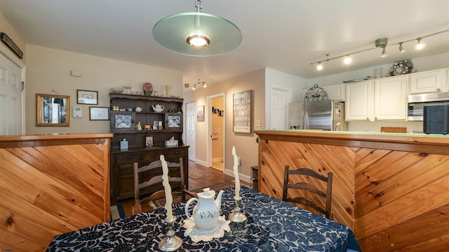 dining area with rail lighting and baseboards