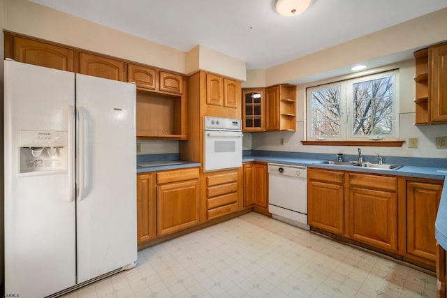 kitchen featuring open shelves, white appliances, light floors, and a sink