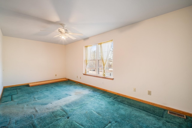 carpeted empty room with visible vents, baseboards, and a ceiling fan