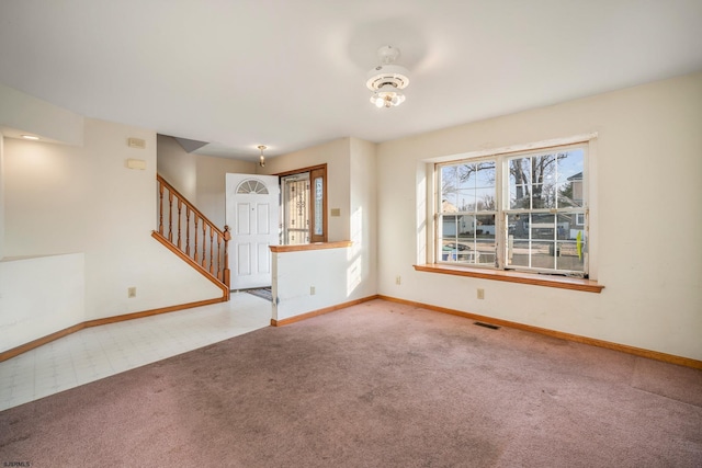 unfurnished living room with stairs, carpet flooring, baseboards, and visible vents