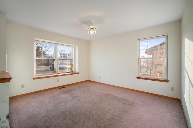 empty room featuring visible vents, carpet, and baseboards