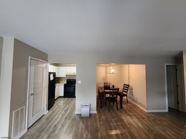 dining space featuring wood finished floors, visible vents, and baseboards