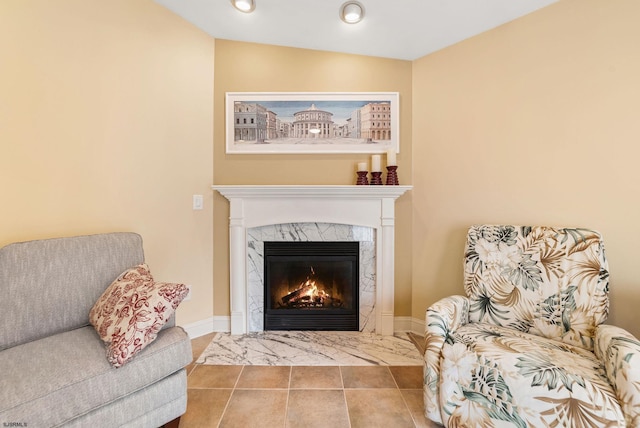 living area with recessed lighting, a premium fireplace, and baseboards