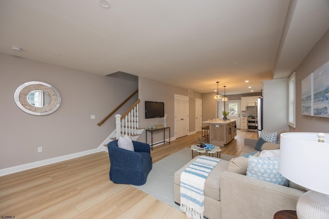 living room featuring recessed lighting, stairway, light wood-style flooring, and baseboards