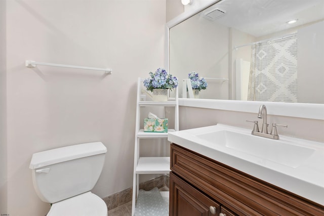 bathroom featuring vanity, a shower with shower curtain, visible vents, tile patterned flooring, and toilet