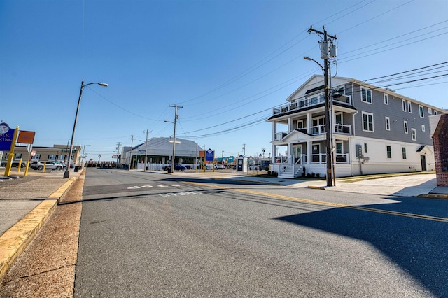 view of road with sidewalks, curbs, and street lighting