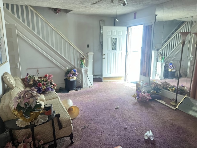 unfurnished living room featuring stairs, carpet flooring, a healthy amount of sunlight, and a textured ceiling