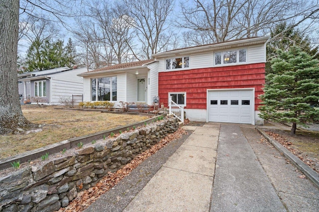 tri-level home with concrete driveway and a garage