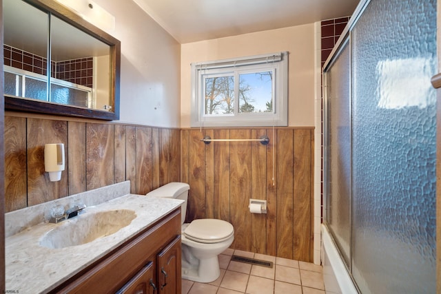 full bath with wooden walls, visible vents, tile patterned flooring, wainscoting, and toilet