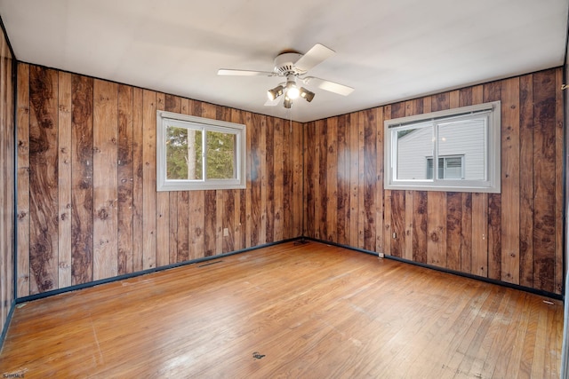 unfurnished room with hardwood / wood-style floors, baseboards, visible vents, and ceiling fan