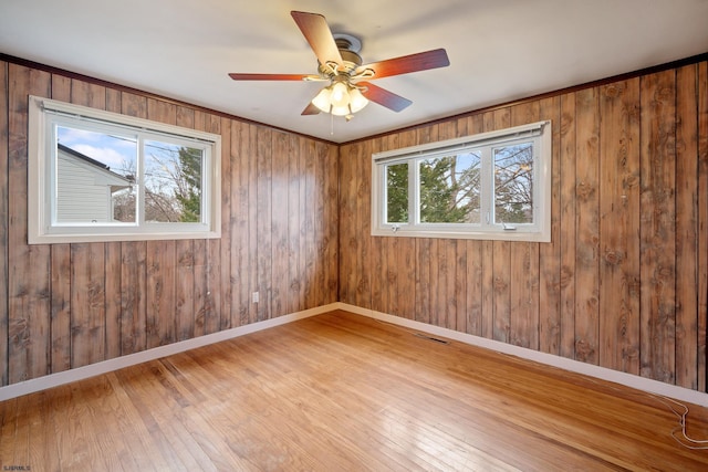 spare room featuring a ceiling fan, hardwood / wood-style flooring, baseboards, and visible vents