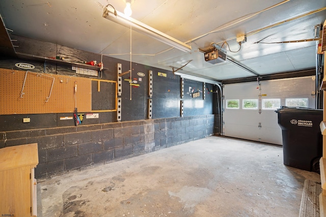 garage with concrete block wall and a garage door opener