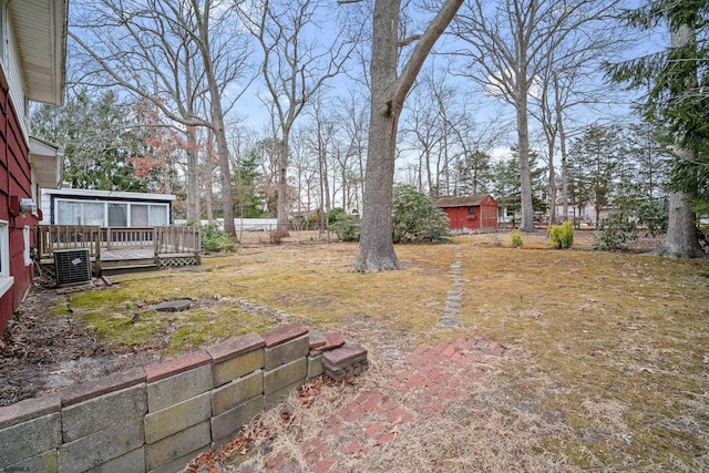 view of yard with cooling unit, a deck, and fence