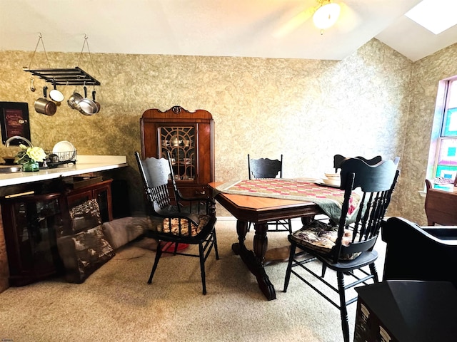 dining space featuring light colored carpet, ceiling fan, and wallpapered walls