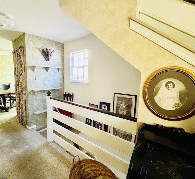 hallway featuring an upstairs landing and carpet flooring