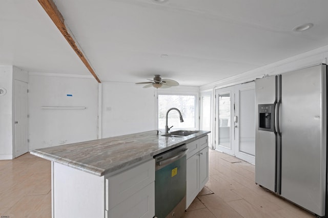 kitchen featuring a sink, ceiling fan, light stone countertops, stainless steel appliances, and a kitchen island with sink