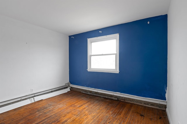 empty room with baseboard heating and hardwood / wood-style floors