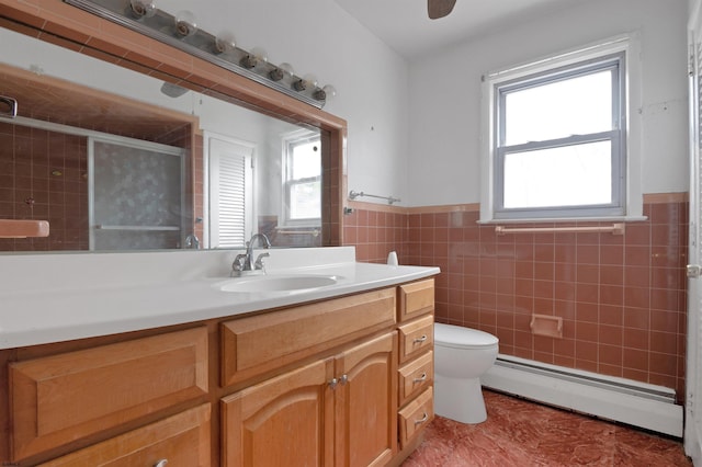 full bathroom featuring toilet, tile walls, plenty of natural light, and baseboard heating