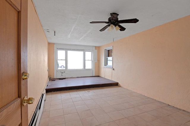 empty room featuring ceiling fan and a baseboard radiator