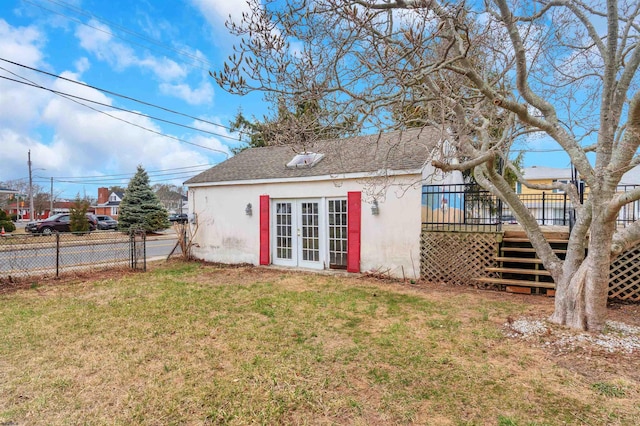 back of property with fence, a wooden deck, stairs, a lawn, and french doors