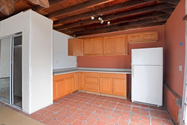 kitchen featuring light brown cabinetry, light countertops, beam ceiling, wooden ceiling, and freestanding refrigerator