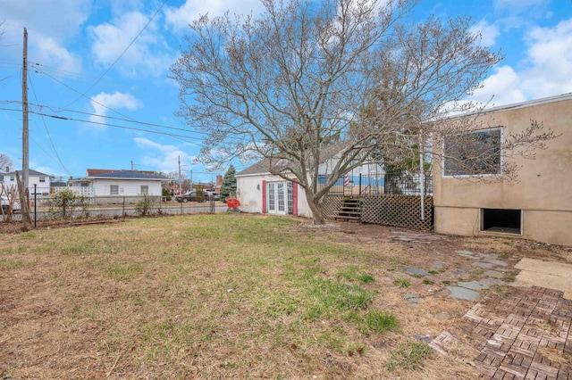 view of yard with french doors, a wooden deck, and fence