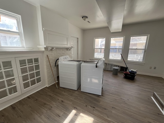 clothes washing area featuring dark wood finished floors, laundry area, plenty of natural light, and independent washer and dryer