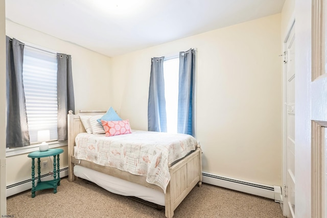 bedroom featuring a baseboard heating unit and light colored carpet