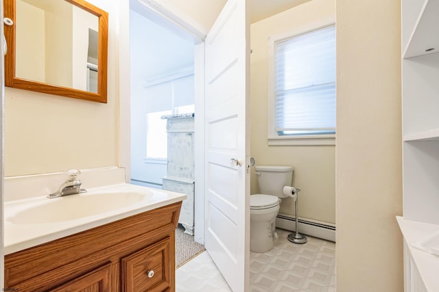 bathroom with a healthy amount of sunlight, toilet, vanity, and a baseboard radiator