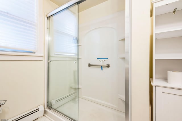 bathroom with plenty of natural light, a shower stall, and a baseboard heating unit