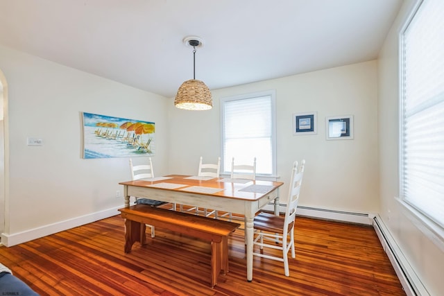 dining space with plenty of natural light, baseboard heating, and wood finished floors