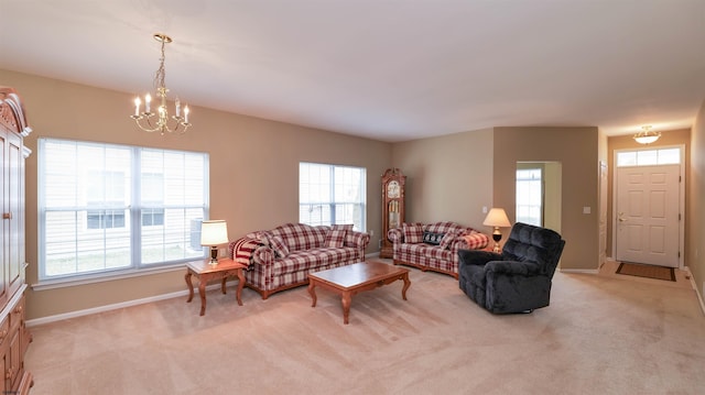 living area with a notable chandelier, light colored carpet, and plenty of natural light