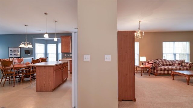 kitchen featuring an inviting chandelier, decorative light fixtures, light countertops, and open floor plan