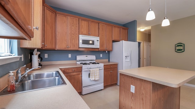 kitchen with white appliances, light countertops, brown cabinets, and a sink