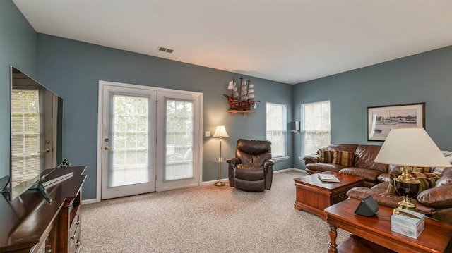 living room with visible vents, baseboards, carpet, and a healthy amount of sunlight