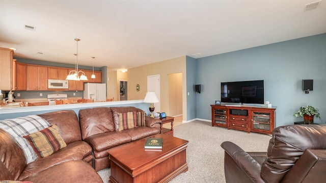 living area with visible vents, light carpet, a notable chandelier, and baseboards