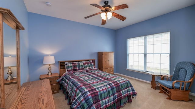 carpeted bedroom with a ceiling fan and baseboards