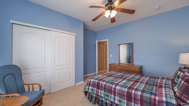 carpeted bedroom with a closet, baseboards, visible vents, and a ceiling fan