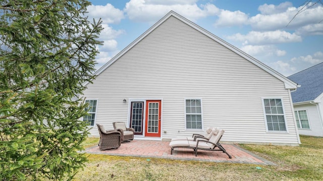 back of property with a patio area and a lawn