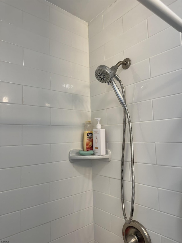 interior details featuring tiled shower